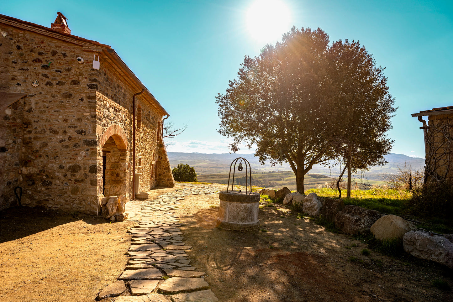 Podere tipico della Toscana con pozzo centrale e paesaggio delle colline